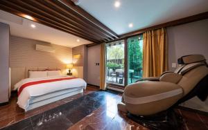 a bedroom with a bed and a chair and a window at R Hotel in Bucheon