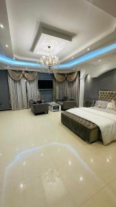 a large bedroom with a bed and a chandelier at Suite Room with big balcony in Al Rahba