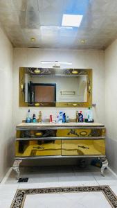 a bathroom with a yellow counter with a mirror at Suite Room with big balcony in Al Rahba