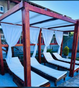 a group of four beds with white curtains at Complejo Brisas del Mar in San Bernardo