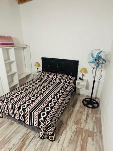 a bedroom with a bed with a black and white blanket at Complejo Brisas del Mar in San Bernardo
