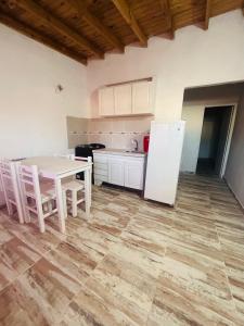 a kitchen with a white table and a white refrigerator at Complejo Brisas del Mar in San Bernardo