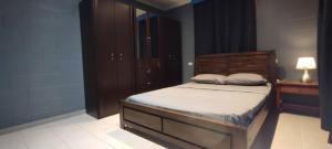 ein Schlafzimmer mit einem Bett mit hölzernem Kopfteil und einer Lampe in der Unterkunft LodgeToks in Port Moresby