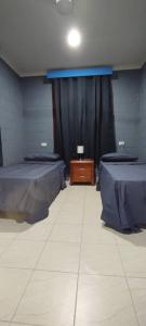 ein Zimmer mit zwei Betten und einem schwarzen Vorhang in der Unterkunft LodgeToks in Port Moresby