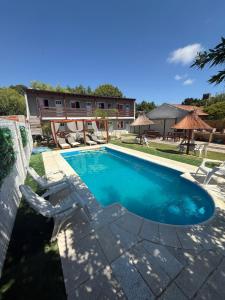 a swimming pool with two lawn chairs and a swimming pool at Complejo Brisas del Mar in San Bernardo