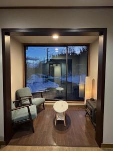 a room with a window with a chair and a table at Daiju Myoko - Renovated in 2025 in Myoko