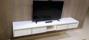 a flat screen tv sitting on top of a white cabinet at Sweethome MAMA in Kuala Terengganu