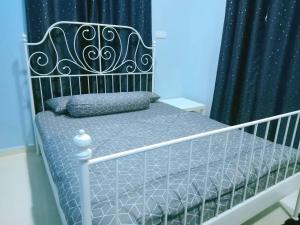 a bed in a bedroom with a black curtain at Sweethome MAMA in Kuala Terengganu