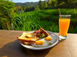 a plate of eggs and toast and a glass of orange juice at Umaku Bali Homestay in Munduk