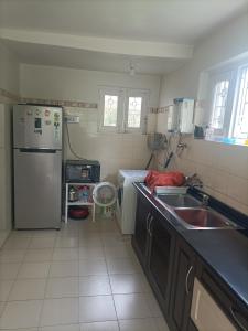 a small kitchen with a sink and a refrigerator at Snow Leopard Lodge in Srinagar