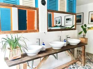 a bathroom with two sinks and two mirrors at La Mera Homestay in Ben Tre +73 photos
