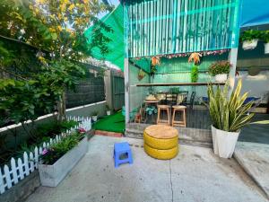 a patio with a table and chairs and plants at La Mera Homestay in Ben Tre