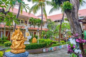 a statue in front of a building with palm trees at Grand Melka Hotel in Lovina