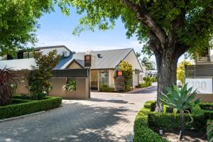 a building with a tree in front of a street at North Adelaide Boutique Stays Accommodation in Adelaide
