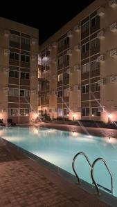 a large swimming pool in front of a building at night at Your Cozy Space in Stanford Suites 3 Brgy Inchican Silang Cavite in Silang