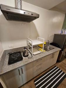 a kitchen with a sink and a stove at Your Cozy Space in Stanford Suites 3 Brgy Inchican Silang Cavite in Silang