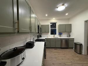 a large kitchen with green cabinets and a sink at Spacious 4BR Home Pool and Comfort in Columbus +27 photos