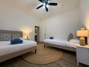 a bedroom with two beds and a ceiling fan at Spacious 4BR Home Pool and Comfort in Columbus