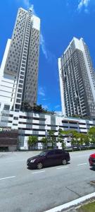 a black car parked in front of two tall buildings at Peace home 03 in Cyberjaya