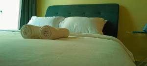 a large white bed with white pillows and a blue headboard at Peace home 03 in Cyberjaya +13 photos