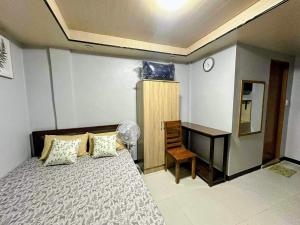 a bedroom with a bed and a desk in it at IBM Homestay in Butuan