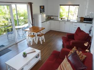 a living room with a red couch and a table at Bushland Breeze - Self Contained Unit in Gladstone