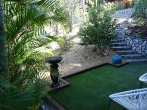 a garden with a vase on the grass and a yard at Bushland Breeze - Self Contained Unit in Gladstone