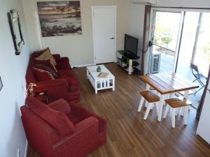 a living room with a red couch and a table at Bushland Breeze - Self Contained Unit in Gladstone +20 photos