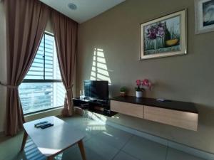 a living room with a table and a television at Peace home 03 in Cyberjaya