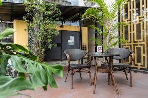 two chairs and a table on a patio with plants at Club Mahindra Mac Boutique Hotel in Bangkok