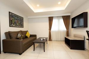 a living room with a couch and a tv at Club Mahindra Mac Boutique Hotel in Bangkok