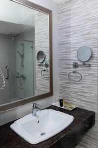 a bathroom with a sink and a large mirror at Club Mahindra Mac Boutique Hotel in Bangkok +57 photos
