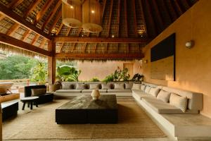 a living room with a couch and a table at Casa Yute Boutique Hotel Playa Aragon in San Agustinillo
