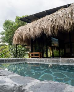a resort with a swimming pool and a straw hut at Jungla EcoLuxury Resort in Villeta +25 photos
