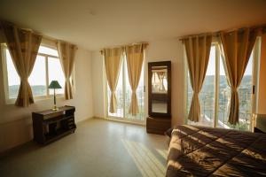 a bedroom with windows and a bed and a mirror at Casa del Pintor Guesthouse in Guanajuato