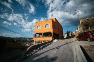 an orange house on the side of a street at Casa del Pintor Guesthouse in Guanajuato +8 photos