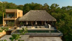 a resort with a swimming pool and a thatch roof at Casa Yute Boutique Hotel Playa Aragon in San Agustinillo