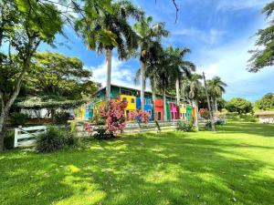 a colorful train in a park with palm trees at Pousada Villa Felicidade in Guarapari