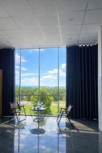 a room with chairs and a table in front of a large window at Ánh Mai Hotel in Bảo Lộc