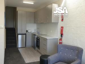 a kitchen with a blue chair in a room at Parkwood 7 in Jindabyne