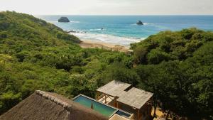 a view of a beach with a house and the ocean at Casa Yute Boutique Hotel Playa Aragon in San Agustinillo +38 photos