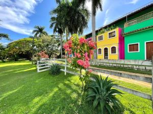 a colorful house with flowers in the yard at Pousada Villa Felicidade in Guarapari