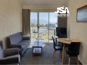 a living room with a couch and a table at Parkwood 7 in Jindabyne