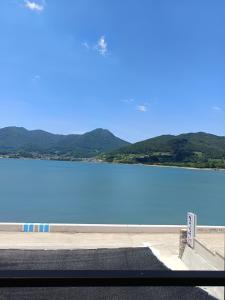 a view of a large lake with mountains in the background at Namhae Soljeong Pension in Namhae