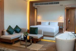 a hotel room with a bed and a couch at K2Green Hotel in Kanchanaburi City