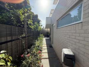 a garden path next to a building with a fence at Cowes Central Beach Villa II in Cowes
