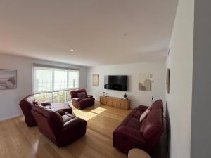 a living room with two couches and a television at Cowes Central Beach Villa II in Cowes