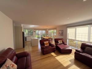 a living room with leather couches and a table at Cowes Central Beach Villa II in Cowes