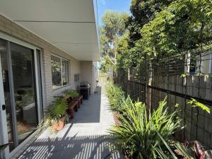 a porch of a house with benches and a fence at Cowes Central Beach Villa II in Cowes