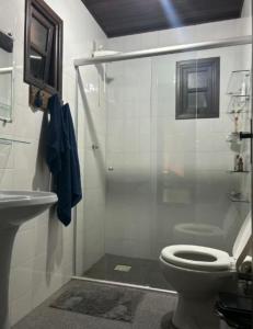 a bathroom with a shower and a toilet and a sink at Lar Zen in Garopaba